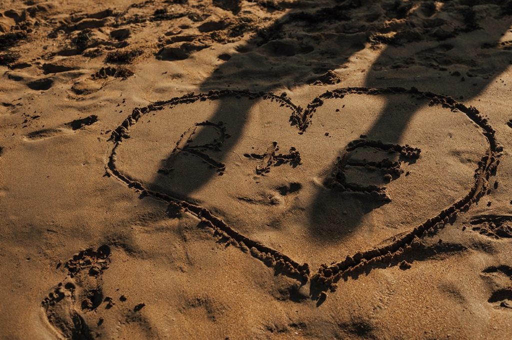 Writing on the sand, and couple's shadow